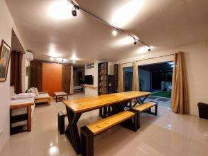 a dining room with a wooden table and benches at YB Rooftop Residence in General Santos