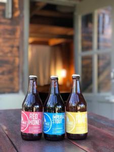 tre bottiglie di birra sedute su un tavolo di legno di Fiordo B&B and Beer-Spa a Potrerillos