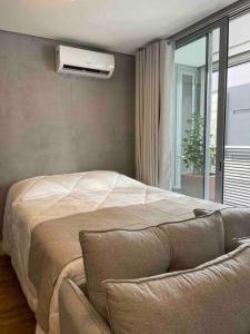 a bedroom with a bed and a chair and a window at Hospede sem sair de casa/Studio in Sao Paulo