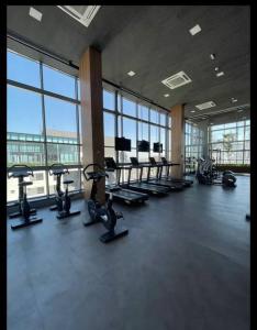 a gym with treadmills and ellipticals in a room with windows at Hospede sem sair de casa/Studio in Sao Paulo