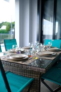 a table with plates and wine glasses on it at La villa O'rizon in Le Diamant