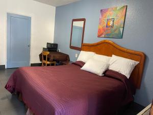 een slaapkamer met een bed met een rode deken en een spiegel bij Laurel Inn in Oakland