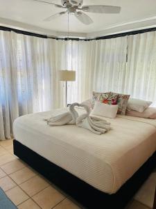 a large bed in a bedroom with a ceiling fan at Villa La Fortuna Altos del Maria in Filipina