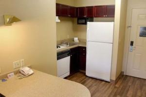 a kitchen with a white refrigerator and a counter at LoneStar Suites in Webster