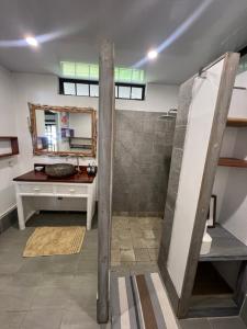 Fare Tetahora في Tevaitoa: حمام مع دش مع حوض ومكتب