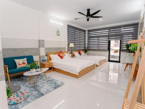 a bedroom with a bed and a couch and a fan at ALOHA SAIGON HOSTEL by Local Travel Experts - Newly opened, Less-touristy location, Spacious rooms, Glass shower bathroom, Free breakfast, Quiet alley and Cultural exploration in Ho Chi Minh City