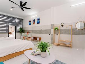 ALOHA SAIGON HOSTEL by Local Travel Experts - Newly opened, Less-touristy location, Spacious rooms, Glass shower bathroom, Free breakfast, Quiet alley and Cultural exploration في مدينة هوشي منه: غرفة نوم بسرير وطاولة ومروحة سقف