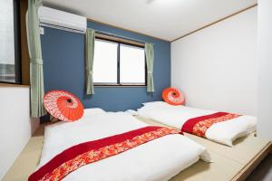 two beds in a room with blue walls and windows at 匯家風花ビル in Tokyo