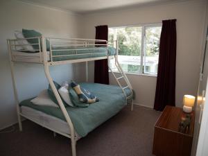 Etagenbett in einem Zimmer mit Fenster in der Unterkunft Fun in the Sun in Cable Bay