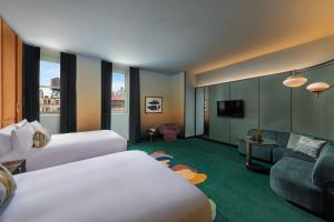 a hotel room with two beds and a couch at W New York - Union Square in New York