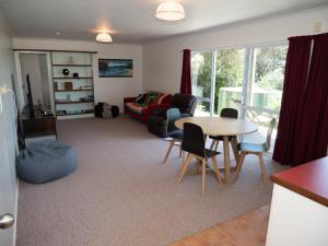 ein Wohnzimmer mit einem Tisch und einem Sofa in der Unterkunft Fun in the Sun in Cable Bay