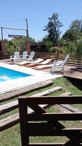 a group of lounge chairs and a swimming pool at Casa de Campo, con Pileta y Asador Criollo!! - "La Ranchada" in Gualeguaychú