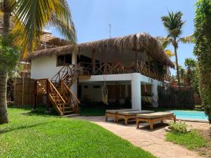 a house with a thatched roof and a pool at Terraza Salvatore, Casa en Las Pocitas de Máncora in Máncora