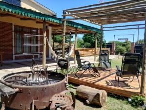 a wooden deck with a fire pit and a pergola at Casa de Campo, con Pileta y Asador Criollo!! - "La Ranchada" in Gualeguaychú