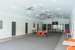 ein leeres Zimmer mit roten Stühlen und Tischen in der Unterkunft Eaglehawk Park Canberra in Canberra