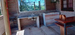 an outdoor kitchen with a sink and a window at Casa de Campo, con Pileta y Asador Criollo!! - "La Ranchada" in Gualeguaychú