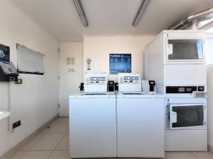a laboratory with white appliances in a room at Condominio Pacífico 2800 in La Serena
