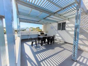 a patio with a table and chairs under a pergola at Condominio Pacífico 2800 in La Serena
