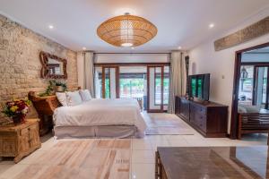 une chambre avec un grand lit et une télévision dans l'établissement Sama Sama Villa, à Nusa Dua 34 autres photos