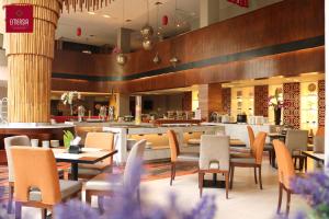 a restaurant with tables and chairs and a bar at Emersia Hotel & Resort Batusangkar in Batusangkar