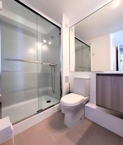 biała łazienka z toaletą i prysznicem w obiekcie Condominio Pacífico 3100 w mieście La Serena