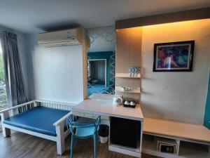 Zimmer mit einem Schreibtisch und einer blauen Bank in der Unterkunft D@Sea Hotel in Jomtien Beach
