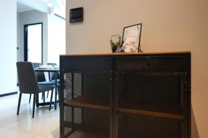 a black dresser in a living room with a table at OPUS Residence by Calm Sojourn, Kuala Lumpur City Centre in Kuala Lumpur