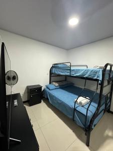 1 dormitorio con litera y escritorio en Twoanis Apartment, en Tambor