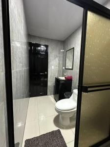 baño con aseo y puerta negra en Twoanis Apartment, en Tambor
