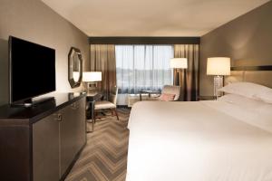 a hotel room with a large bed and a flat screen tv at Sheraton Bucks County Langhorne in Langhorne