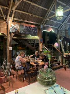 a group of people sitting at a table in a restaurant at Hoi An Sea Sunset Villa & Bar in Hoi An