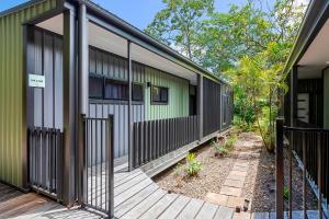 an entrance to a house with a wooden deck at Kipara Tropical Rainforest Retreat in Airlie Beach