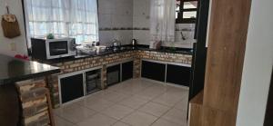 cocina con fregadero y microondas en Casa Vila da gloria, en São Francisco do Sul