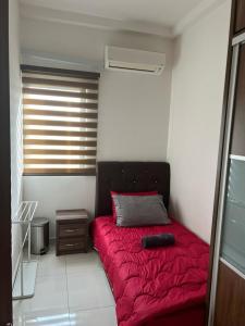 ein Schlafzimmer mit einem roten Bett mit einer roten Decke in der Unterkunft The Foureigns Seasons Garden in Kuala Lumpur