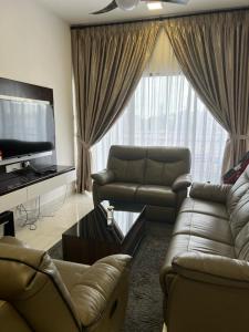 ein Wohnzimmer mit 2 Sofas und einem TV in der Unterkunft The Foureigns Seasons Garden in Kuala Lumpur