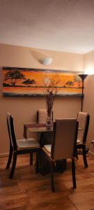 mesa de comedor y sillas con una pintura en la pared en Playa Tomé Chile, en Tomé