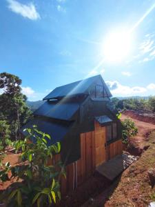 una casa con un techo negro en la parte superior de un campo en Finca Makambu, en Platanillo