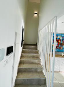 a staircase in a room with a white wall at La villa O'rizon in Le Diamant