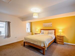 a bedroom with yellow walls and a bed and a window at 2 Bed in Falkirk 90602 in Bonnybridge