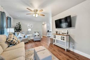 a living room with a couch and a flat screen tv at House of Charm! Bike Trails & New Walmart HQ in Bentonville