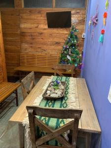 a wooden table with a christmas tree in a room at PIEDRAS PRECIOSAS in Villa Gesell