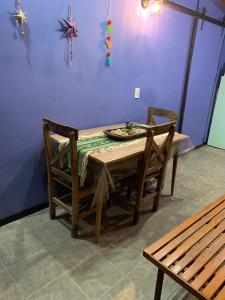 a dining room table with two chairs and a bench at PIEDRAS PRECIOSAS in Villa Gesell