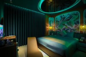 una camera con letto in una stanza con illuminazione verde di Chiic House 4 - Khách sạn tình yêu a Quy Nhon