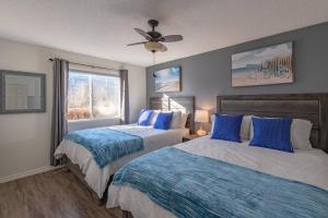 a bedroom with two beds and a ceiling fan at B211 MTN View ground floor town house- 2BD, Sleeps 8, hot tub, free parking, close to Banff in Canmore