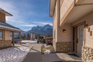 ein Auto, das auf einem Parkplatz neben einem Gebäude parkt in der Unterkunft B211 MTN View ground floor town house- 2BD, Sleeps 8, hot tub, free parking, close to Banff in Canmore