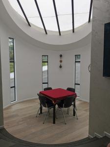 - une salle à manger avec une table rouge et deux chaises dans l'établissement Luxury Harbour view, à Dunedin