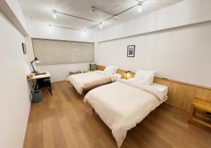 a bedroom with two beds and a desk with a lamp at HERE.Tokyo in Tokyo