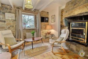 a living room with a stone fireplace and chairs at Kermaria in Plougrescant