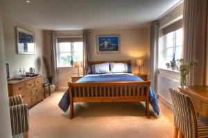 1 dormitorio con 1 cama y 2 ventanas en Sunset House Bed and Breakfast, en East Harling