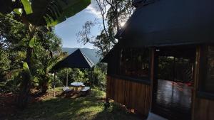 a small house with a black roof and a table at Finca Makambu in Platanillo